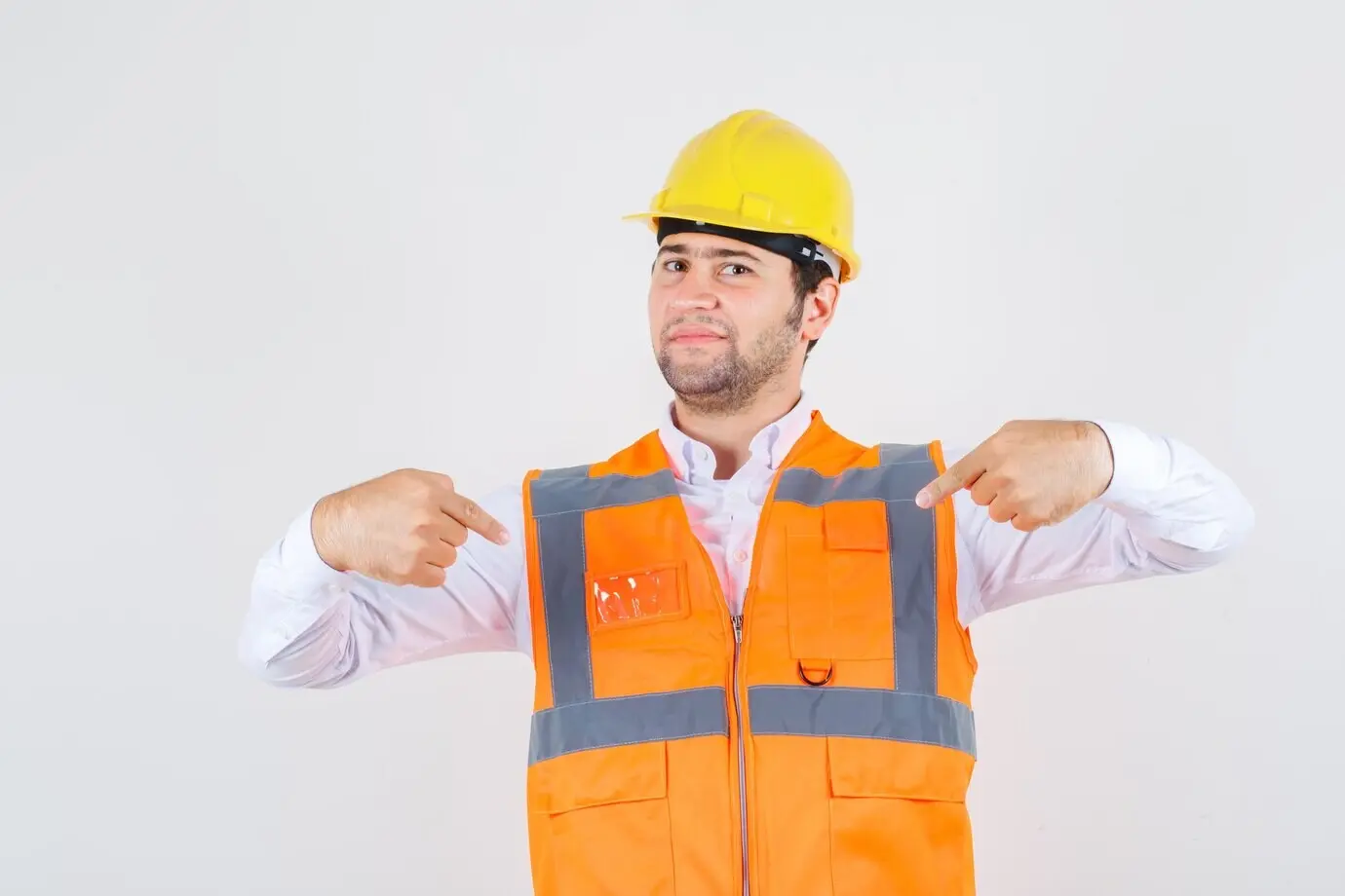 Мужчина-строитель в рубашке и форме указывает на себя и выглядит уверенным, вид спереди.